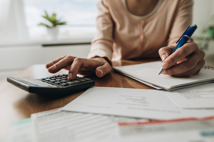 woman at table with calculator and paperwork