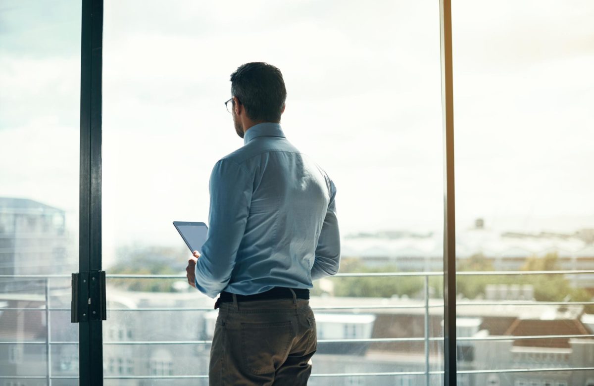 man at office window overlooking view