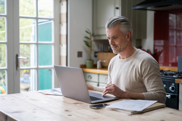 man in 50s reviewing retirement plan on computer