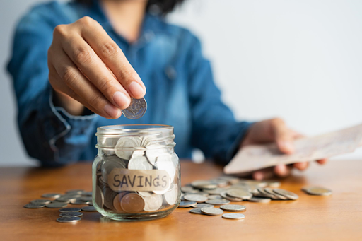 woman adding coins to retirement savings jar