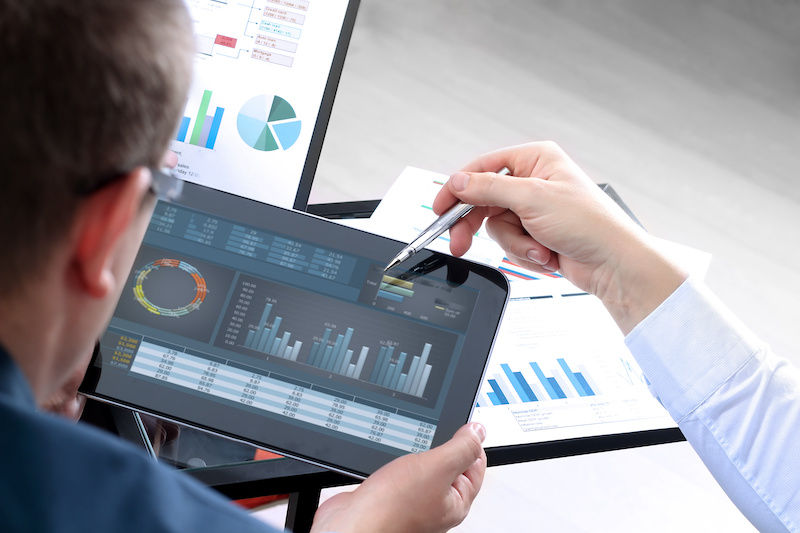 Business colleagues working and analyzing financial figures on a graphs