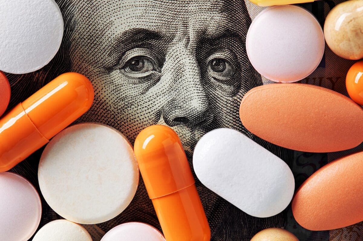 Close-up of prescription pills and capsules layered over U.S. currency, symbolizing rising healthcare costs, medical inflation, and the impact on retirement income planning for investors in the Chicagoland area.