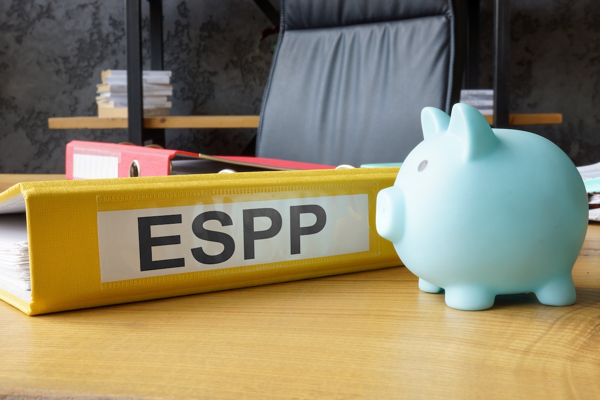 Blue piggy bank beside a yellow ESPP binder, representing employee stock purchase plans, equity compensation, and employer stock financial planning.