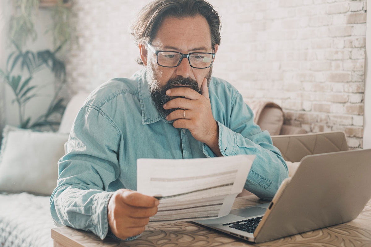 Man reviewing investment statements to identify a concentrated portfolio and investment risk before retirement